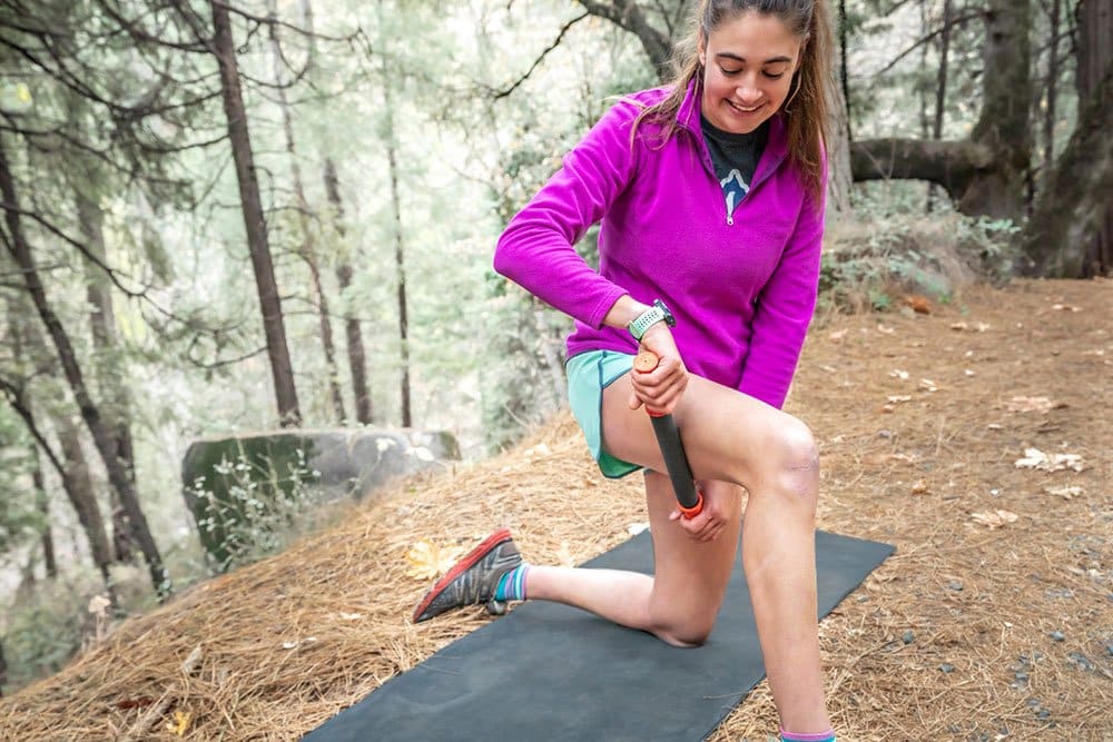 TigerTail_November_2019_11_Web Woman Rolling her IT Band with the Roadster 11" Handheld Foam Roller