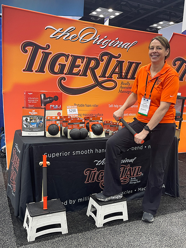 Spring Faussett rolling her legs with The Original 18" Handheld Foam Roller in a running convention