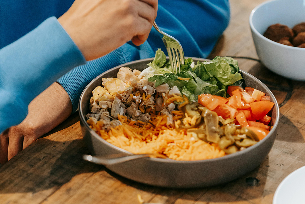 pexels-michael-burrows-7129424_1000px Man eating delicious dish with meat and vegetables
